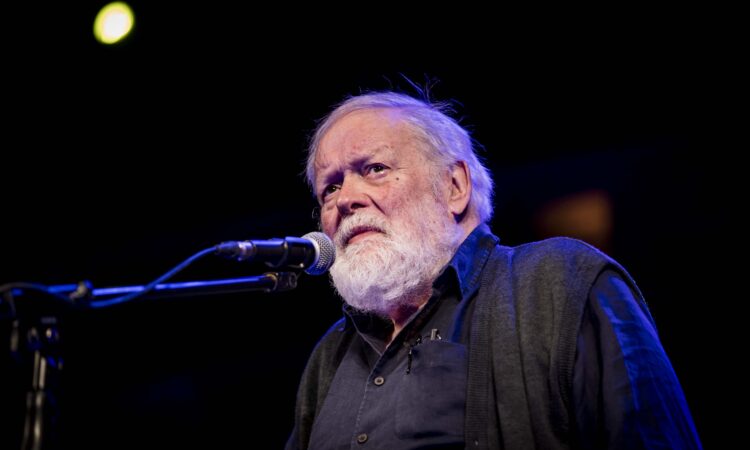 Michael Longley standing at a microphone